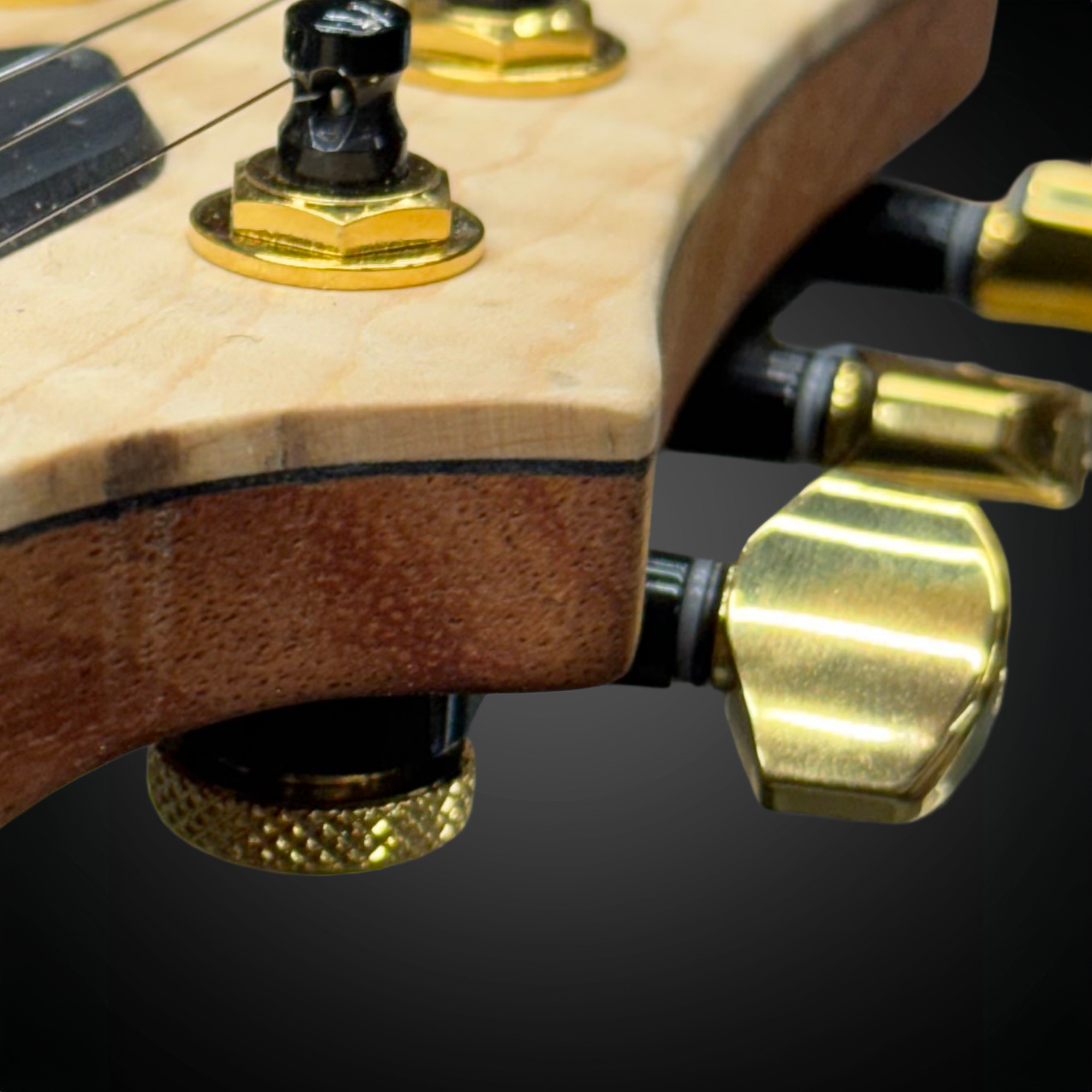 Close-up of a guitar's tuning pegs on a dark background